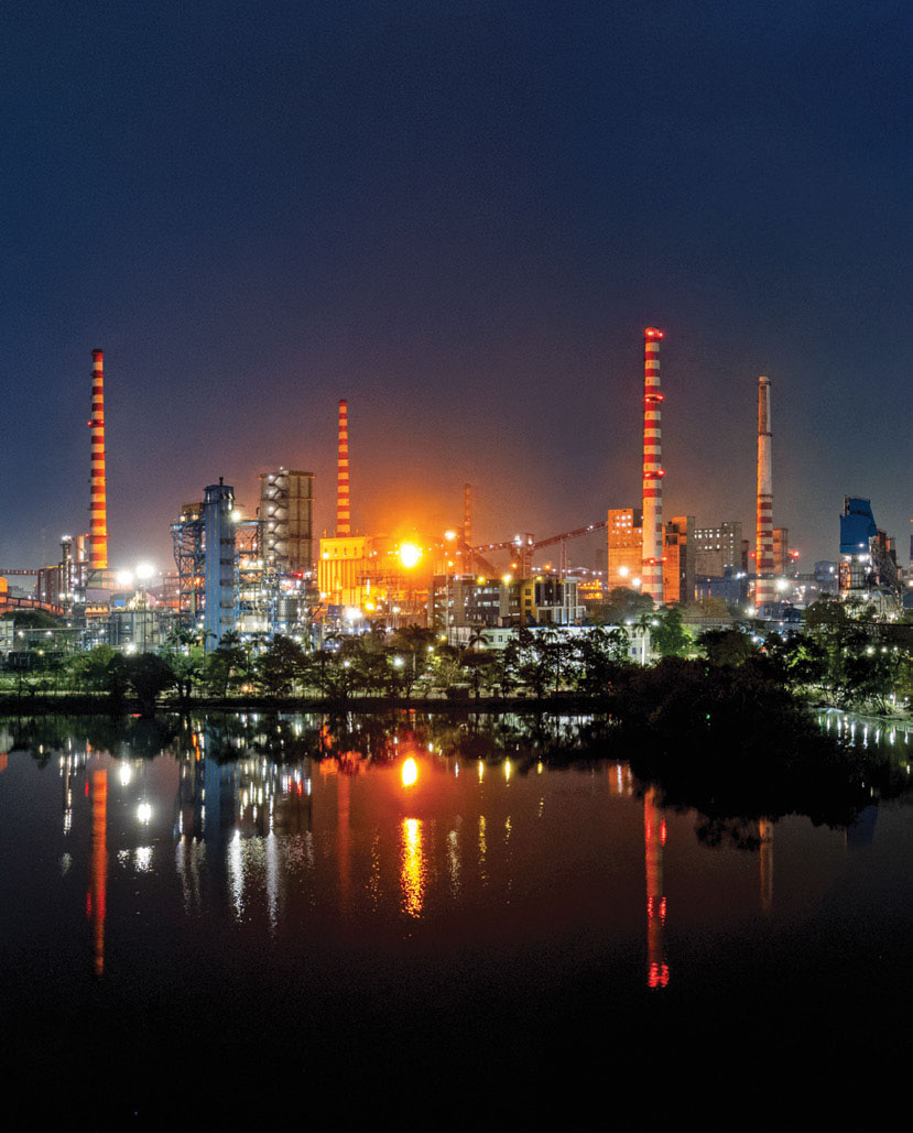 Night view of Tata Steel Jamshedpur plant reflected in water, India